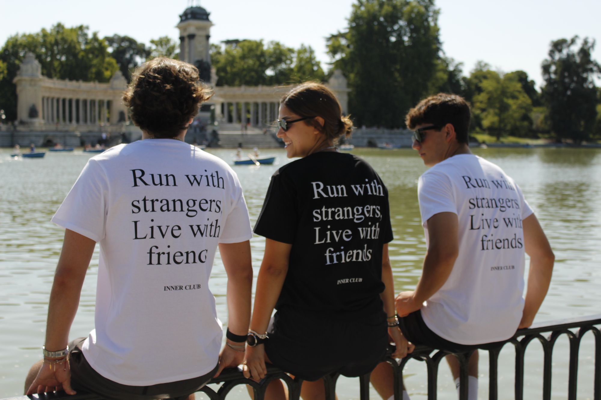 Miembros de Inner Club con camisetas Run with strangers, live with friends frente al lago del Retiro